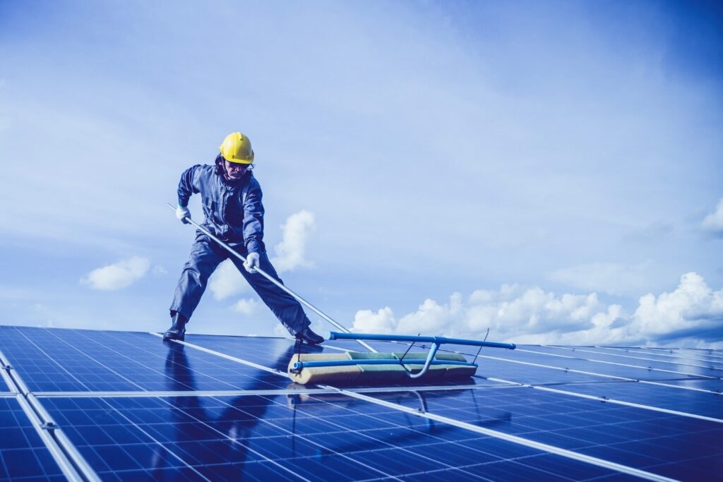 Nettoyage panneau solaire. Un professionnel en train de laver des panneaux photovoltaïques.