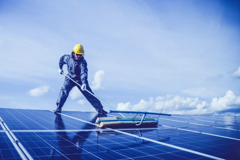 Nettoyage panneau solaire. Un professionnel en train de laver des panneaux photovoltaïques.