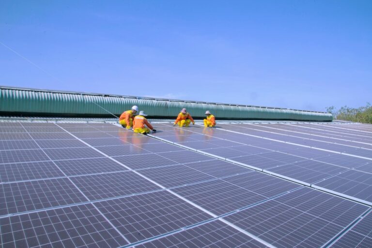 Des techniciens en train de vérifier la performance des panneaux solaires photovoltaïques.